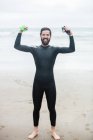Retrato de atleta em pé na praia com as mãos levantadas — Fotografia de Stock
