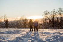 Casal em pé na paisagem coberta de neve — Fotografia de Stock
