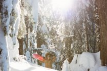 Femme avec snowboard marchant sur la montagne enneigée — Photo de stock