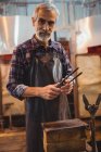 Portrait of glassblower holding tongs at glassblowing factory — Stock Photo