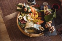 Vários sushi em placa de sushi de bambu em restaurante — Fotografia de Stock