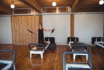 Frau übt Pilates auf Reformer im Fitnessstudio — Stockfoto