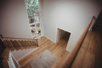 Інтер'єр будинку з дерев'яною підлогою і сходами з білими стінами — стокове фото
