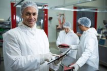 Portrait of technicians using digital tablet at meat factory — Stock Photo