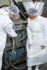 Técnicos examinando máquina de processamento de carne na fábrica de carne — Fotografia de Stock