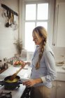 Femme préparant des nouilles dans la cuisine à la maison — Photo de stock