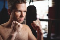 Боксер виконує боксерську позицію в фітнес-студії — стокове фото