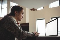 Жінка працює на ноутбуці у вітальні вдома — стокове фото