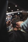 Homem recebendo cabelo aparado pelo estilista com navalha na barbearia — Fotografia de Stock