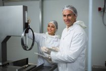 Portrait of technicians maintaining record on clipboard at meat factory — Stock Photo