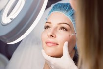 Giovane donna che riceve un'iniezione di botox sul viso in clinica — Foto stock