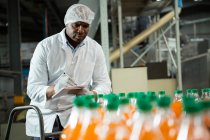 Serious male worker noting in juice factory — Stock Photo
