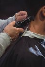 Primer plano del hombre conseguir pelo recortado con trimmer en la peluquería - foto de stock