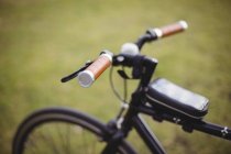 Close-up of bicycle handle in park against green background — Stock Photo