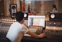 Ingénieur audio utilisant un mixeur dans un studio d'enregistrement — Photo de stock