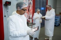 Techniker nutzen digitales Tablet in Fleischfabrik — Stockfoto
