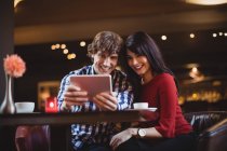 Пара, делающая селфи с помощью цифрового планшета в ресторане — стоковое фото