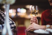 Primo piano della donna che tiene il bicchiere di vino nel ristorante — Foto stock