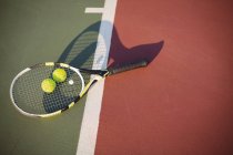 Close-up of tennis racket and balls on court — Stock Photo
