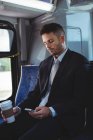 Geschäftsmann mit Einweg-Kaffeetasse und Handy im Bus — Stockfoto