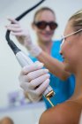 Patiente recevant un traitement d'épilation laser à l'épaule au salon de beauté — Photo de stock