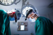 Хирурги носят хирургические лупы во время операции в операционном зале — стоковое фото