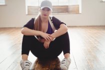 Молода жінка сидить у танцювальній студії — стокове фото