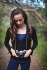 Belle femme debout avec caméra dans la forêt — Photo de stock