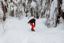 Mann beim Snowboarden am verschneiten Berghang — Stockfoto