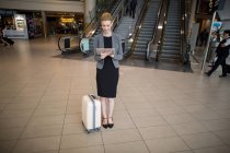 Geschäftsfrau nutzt digitales Tablet am Flughafen — Stockfoto