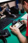 Mann repariert Digitalkamera in Werkstatt — Stockfoto