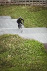Ciclista montando en bicicleta BMX en skatepark - foto de stock