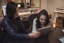 Audio engineers using digital tablet in recording studio — Stock Photo