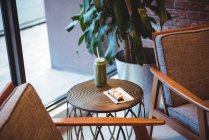 Zumo de batido verde y postre dulce en la mesa en la cafetería - foto de stock