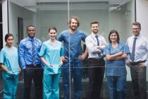 Портрет улыбающихся врачей, стоящих вместе в коридоре больницы — стоковое фото