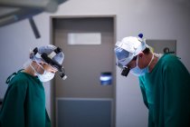 Хирурги носят хирургические лупы во время операции в операционном зале — стоковое фото