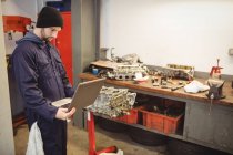 Mecânico usando laptop na garagem de reparação — Fotografia de Stock