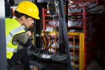 Beautiful female worker driving forklift in warehouse — Stock Photo