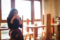 Красивая женщина выпивает чашку кофе в кафе — стоковое фото