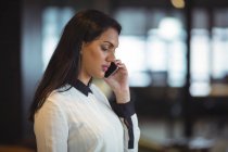 Бізнес-леді розмовляють на мобільному телефоні в офісі — стокове фото
