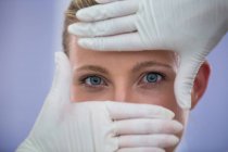 Manos del médico examinando la cara del paciente femenino para el tratamiento cosmético - foto de stock