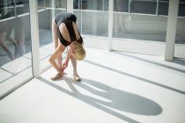 Балерина завязывает балетные туфли в студии — стоковое фото