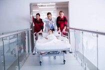 Ärzte schieben Notfall-Trage in Krankenhausflur — Stockfoto