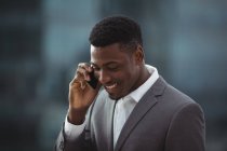Businessman talking on mobile phone on office terrace — Stock Photo