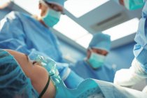 Команда хирургов, выполняющих операции в операционном зале больницы — стоковое фото
