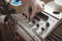 Nahaufnahme einer männlichen Hand beim Einstellen eines Elektrostimulationsgeräts in der Klinik — Stockfoto