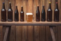 Garrafas de cerveja caseiras e uma caneca de cerveja em uma cervejaria caseira — Fotografia de Stock