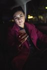Предпринимательница пользуется телефоном, сидя в машине — стоковое фото