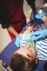 Los paramédicos examinan a un chico herido en la calle - foto de stock