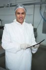 Ritratto di tecnico che tiene una tavoletta digitale in fabbrica di carne — Foto stock